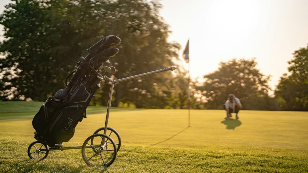 Golftas op een trolley naast de green in de avondzon