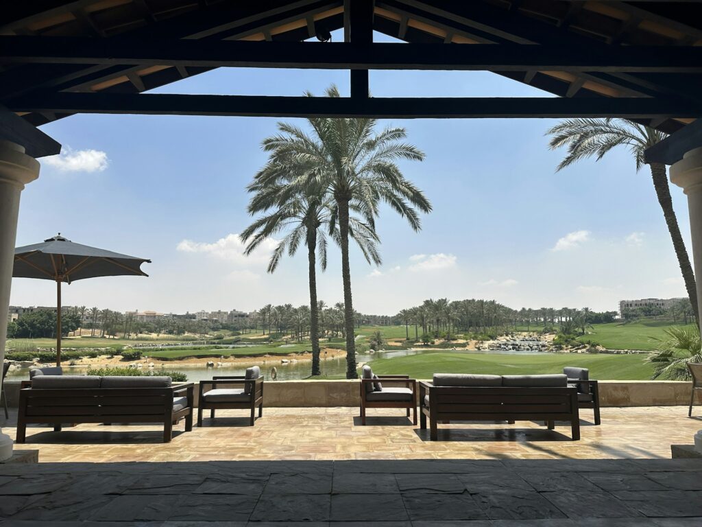 Terras met uitzicht op een golfbaan met palmbomen