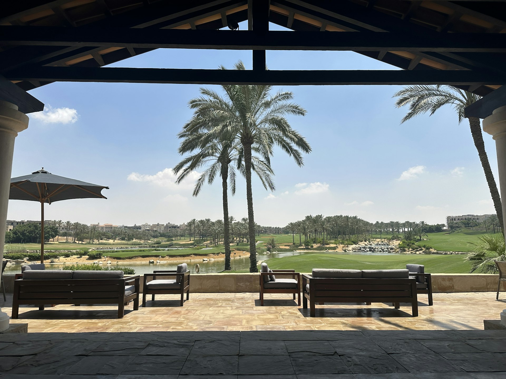 Terras met uitzicht op een golfbaan met palmbomen